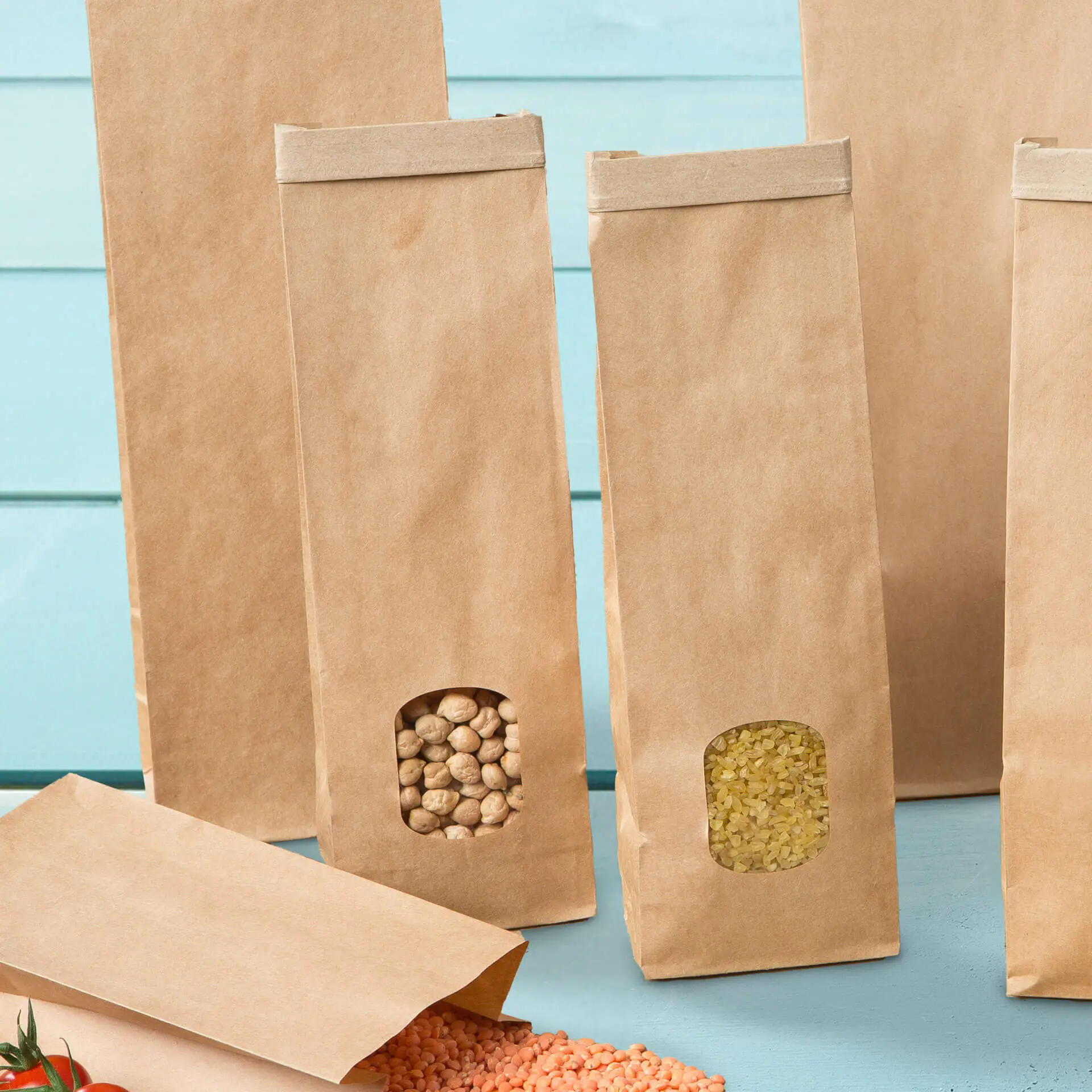 Brązowe papierowe torby z dnem prostokątnym z oknami; jedna torba zawiera ciecierzycę, druga artykuły suche.