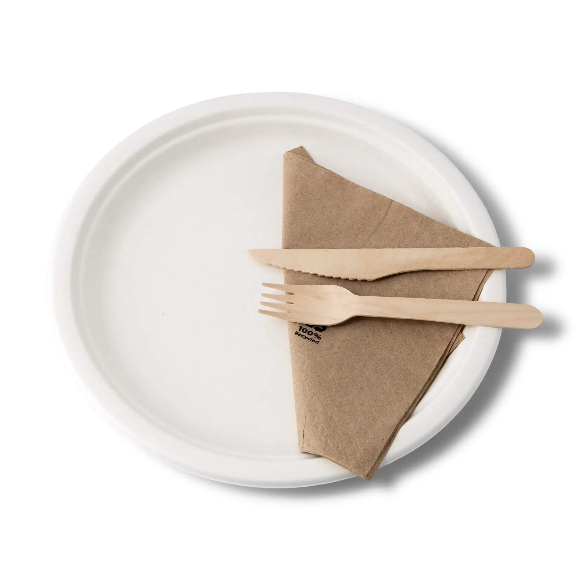 Okrągły biały talerz z trzciny cukrowej złożoną brązową serwetką oraz drewnianym widelcem i nożem na wierzchu.