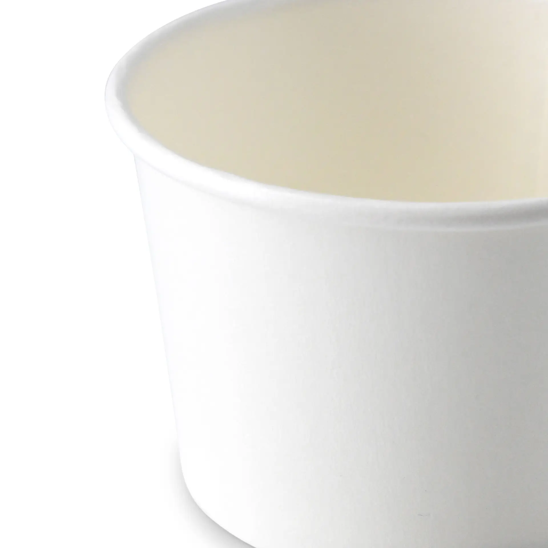 Jedna biała papierowa filiżanka z gładką powierzchnią i lekko zagiętą krawędzią.