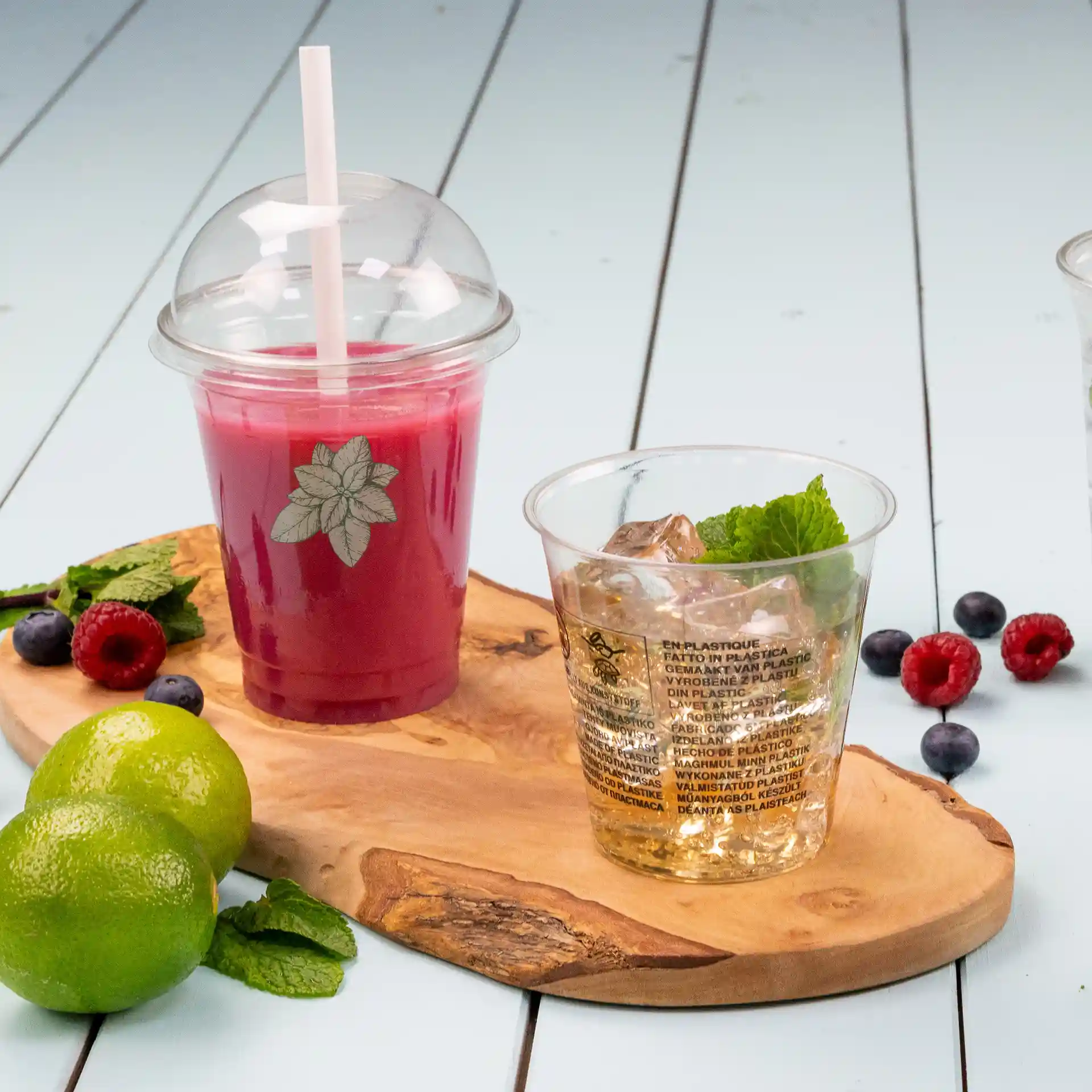 Przezroczysty kubek rPET 12 oz z kopułą i słomką, wypełniony czerwonym napojem, obok kubka lodu i mięty.