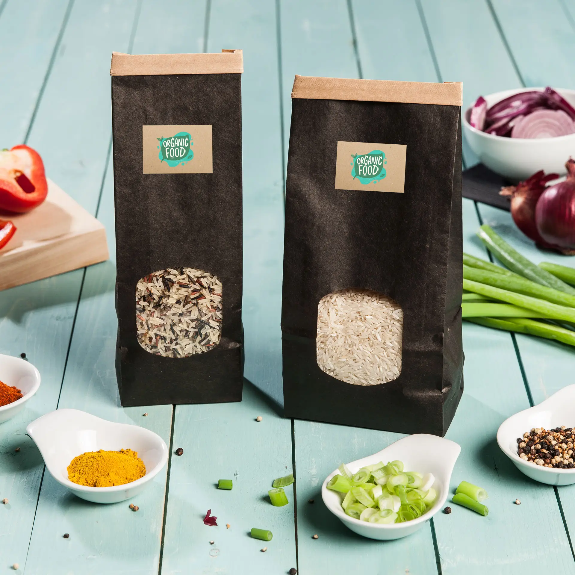 Dwie worki ryżu na drewnianym stole, jeden z mieszanką ziaren, a drugi z białym ryżem, otoczone miseczkami z przyprawami i warzywami.