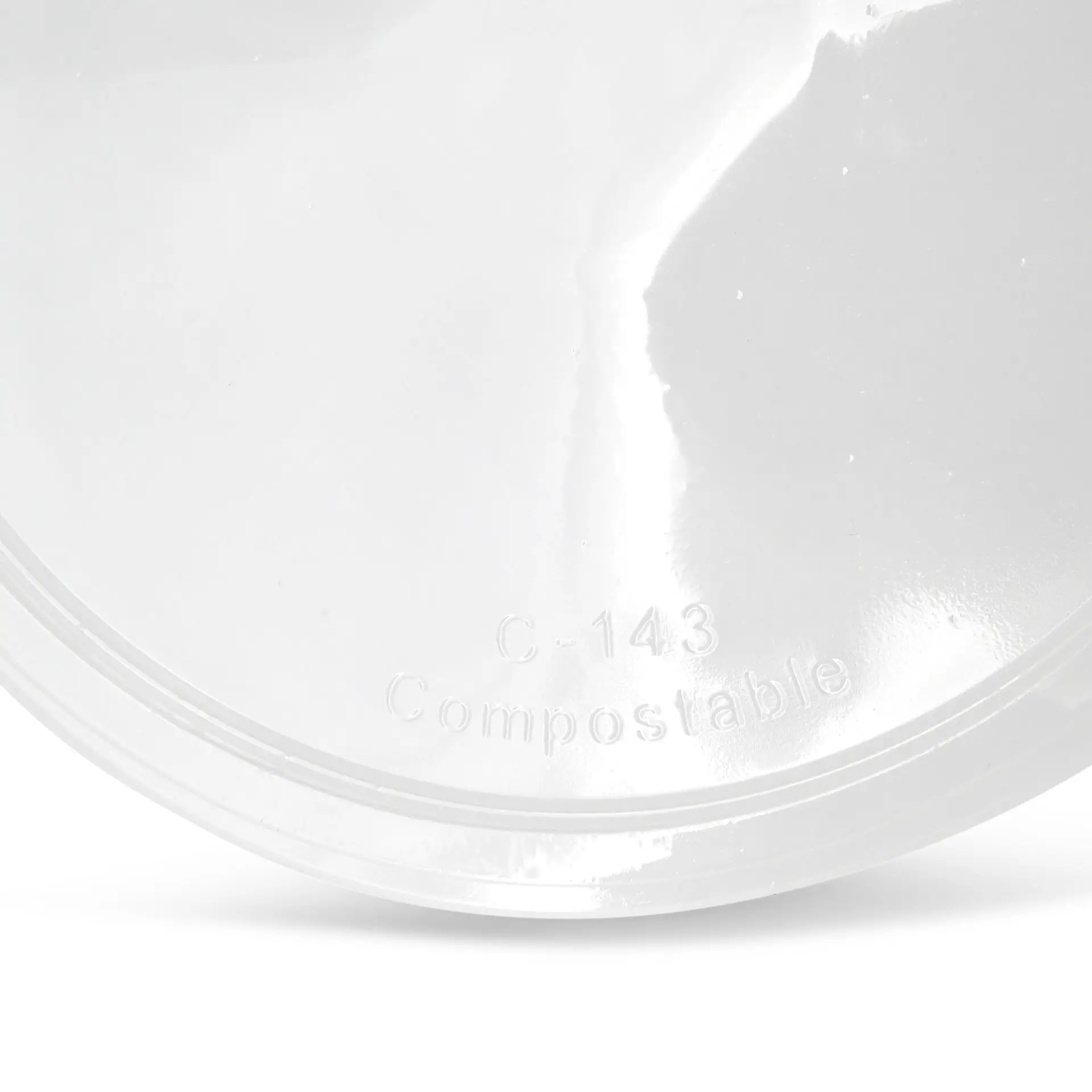 Jeden przezroczysty kompostowalny wieczko z widocznymi oznaczeniami "C-143" i "Kompostowalne".
