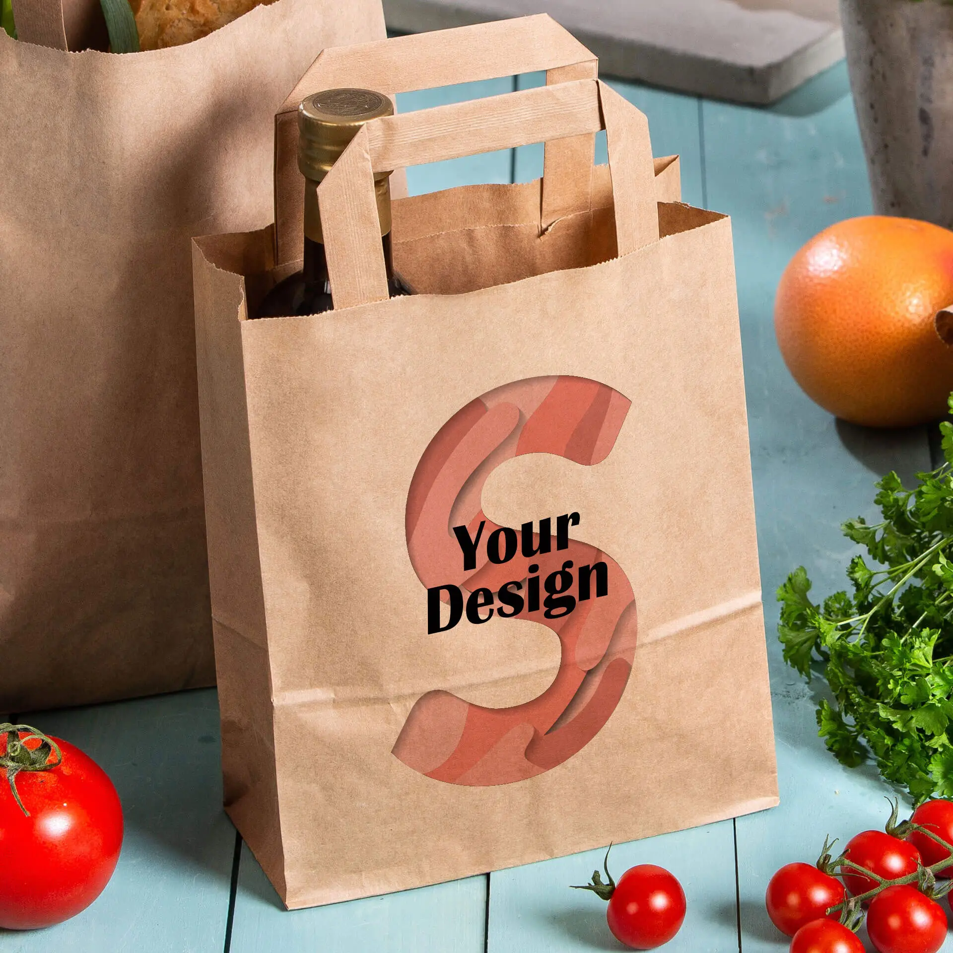 Brązka torba papierowa z możliwością personalizacji, z literą "S" i tekstem "Twój Projekt" obok świeżych produktów.