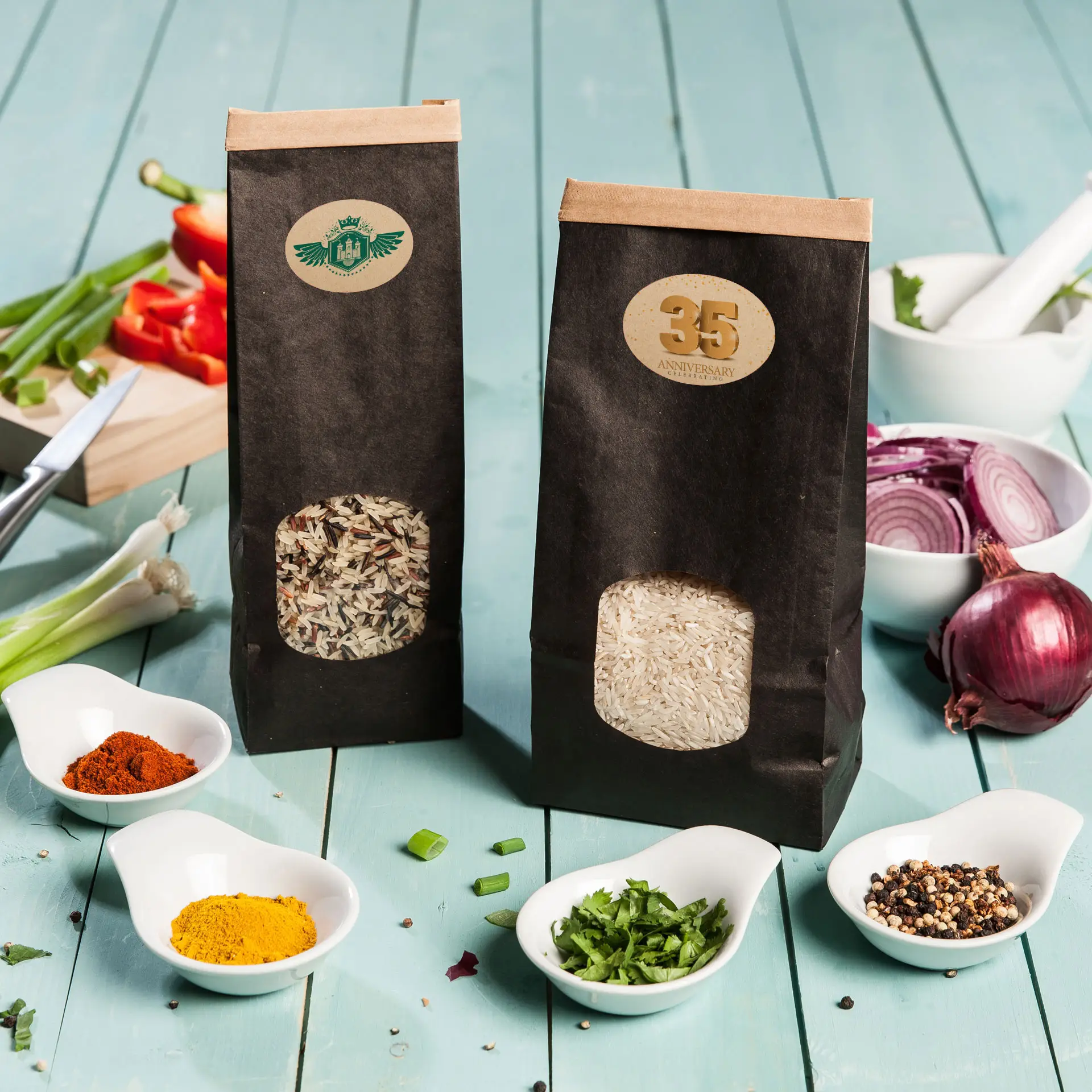 Dwie papierowe torby ryżu, jedna z brązowym ryżem basmati i jedna z białym ryżem, na niebieskiej drewnianej powierzchni z rozsypanymi przyprawami.