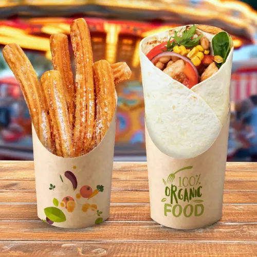 Churros w papierowym kubku obok zapakowanego jedzenia z etykietą "100% Organiczne Jedzenie" na drewnianej powierzchni.