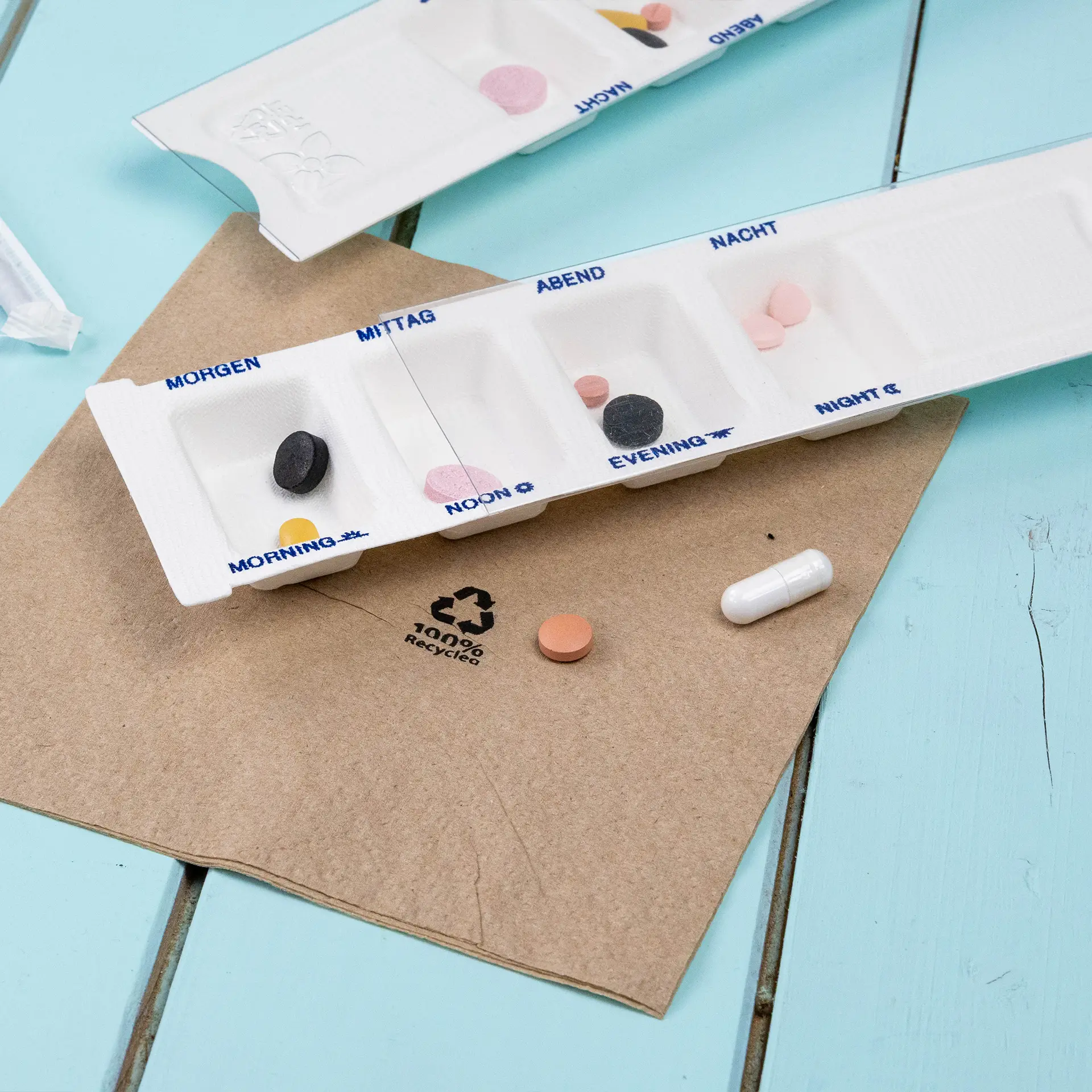 Biodegradowalny dozownik na leki z czterema komorami; wymiary 222 mm x 63 mm x 11 mm; wykonany z bagassy i rPET.